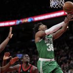 
              Boston Celtics guard Marcus Smart (36) goes for a layup as Toronto Raptors forward Precious Achiuwa, left, and teammate Pascal Siakam, center, look on during first-half NBA basketball game action in Toronto, Monday, March 28, 2022. (Frank Gunn/The Canadian Press via AP)
            