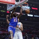 
              New York Knicks center Mitchell Robinson (23) dunks past Los Angeles Clippers forward Nicolas Batum during the first half of an NBA basketball game Sunday, March 6, 2022, in Los Angeles. (AP Photo/Marcio Jose Sanchez)
            