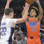 
              Oklahoma City Thunder guard Tre Mann (23) shoots in front of Orlando Magic forward Franz Wagner (22) during the first half of an NBA basketball game, Sunday, March 20, 2022, in Orlando, Fla. (AP Photo/Phelan M. Ebenhack)
            