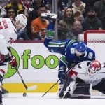 
              Vancouver Canucks' Conor Garland (8) bumps into Washington Capitals goalie Vitek Vanecek as he vies for the puck against John Carlson (74) during the third period of an NHL hockey game Friday, March 11, 2022, in Vancouver, British Columbia. (Darryl Dyck/The Canadian Press via AP)
            