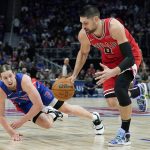 
              Detroit Pistons forward Kelly Olynyk (13) and Chicago Bulls center Nikola Vucevic (9) reach for the loose ball during the first half of an NBA basketball game, Wednesday, March 9, 2022, in Detroit. (AP Photo/Carlos Osorio)
            