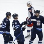 
              Winnipeg Jets' Mark Scheifele (55), Josh Morrissey (44) and Pierre-Luc Dubois (80) celebrate Morrissey's goal against the Columbus Blue Jackets during the second period of an NHL hockey game Friday, March 25, 2022, in Winnipeg, Manitoba. (John Woods/The Canadian Press via AP)
            