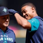 SEATTLE, WASHINGTON - APRIL 15: Jarred Kelenic #10 and Julio Rodriguez #44 of the Seattle Mariners react during batting practice before the game against the Houston Astros at T-Mobile Park on April 15, 2022 in Seattle, Washington. All players are wearing the number 42 in honor of Jackie Robinson Day. (Photo by Steph Chambers/Getty Images)