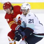 Seattle Kraken center Alex Wennberg (21) works against Calgary Flames right wing Tyler Toffoli (73) during the second period of an NHL hockey game Tuesday, April 12, 2022, in Calgary, Alberta. (Larry MacDougal/The Canadian Press via AP)