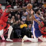 
              Toronto Raptors' Precious Achiuwa (5) and Pascal Siakam (43) team up to steal the ball from Philadelphia 76ers center Joel Embiid (21) during the first half of an NBA basketball game Thursday, April 7, 2022, in Toronto. (Frank Gunn/The Canadian Press via AP)
            