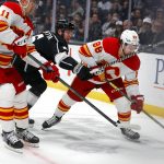 
              Los Angeles Kings defenseman Olli Maatta, center, vies against Calgary Flames forward Mikael Backlund, left, and Calgary Flames forward Andrew Mangiapane (88) during the first period of an NHL hockey game Monday, April 4, 2022, in Los Angeles. (AP Photo/Ringo H.W. Chiu)
            