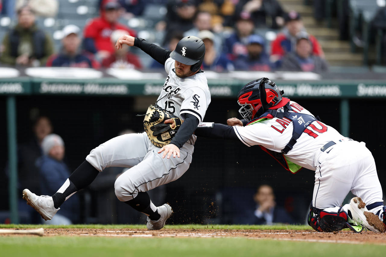 Cleveland Guardians' Bryan Lavastida (10) tags out Chicago White Sox's Adam Engel (15) at home plat...