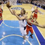 
              FILE - Dallas Mavericks forward Dirk Nowitzki, center, goes up for a shot as Nicolas Batum (88) and Brandon Roy, right, defend, in the first half of an NBA playoff basketball game, April 16, 2011, in Dallas. (AP Photo/Tony Gutierrez, File)
            