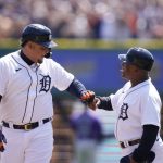 
              Detroit Tigers designated hitter Miguel Cabrera is greeted by the first base coach after his hitting his 3,000th career hit during the first inning of the first baseball game of a doubleheader against the Colorado Rockies, Saturday, April 23, 2022, in Detroit. (AP Photo/Carlos Osorio)
            