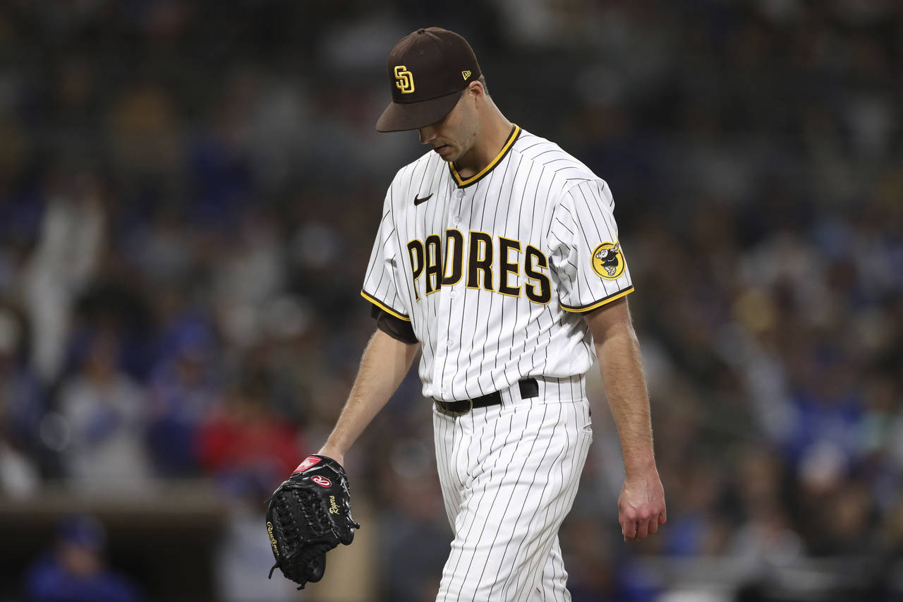 San Diego Padres relief pitcher Taylor Rogers reacts as he walks to the dugout at the end of the ei...