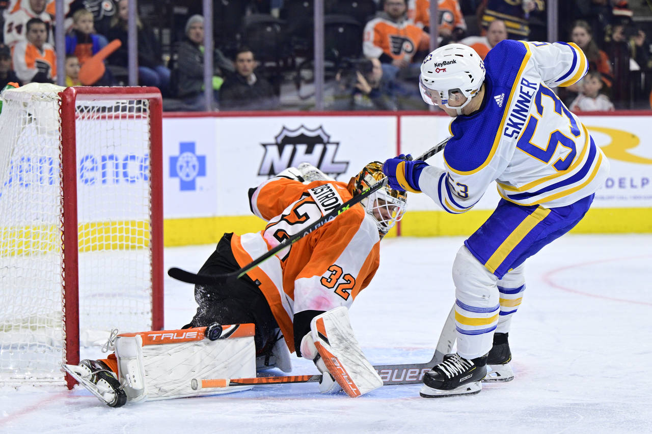 Philadelphia Flyers goaltender Felix Sandstrom, left, makes a save on a shot from Buffalo Sabres' J...