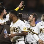 
              San Diego Padres' Austin Nola, second from right, is congratulated by Eric Hosmer, left, after driving in the winning run against the Los Angeles Dodgers in the 10th inning of a baseball game Saturday, April 23, 2022, in San Diego. (AP Photo/Derrick Tuskan)
            
