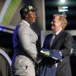 
              Mississippi State offensive lineman Charles Cross shakes hands with NFL Commissioner Roger Goodell after being chosen by the Seattle Seahawks with the ninth pick of the NFL football draft Thursday, April 28, 2022, in Las Vegas. (AP Photo/John Locher )
            
