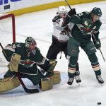 
              Arizona Coyotes' Travis Boyd (72) tries to muscle past Minnesota Wild's Jonas Brodin, right, for the puck as Wild goalie Marc-Andre Fleury defends in the first period of an NHL hockey game, Tuesday, April 26, 2022, in St. Paul, Minn. (AP Photo/Jim Mone)
            