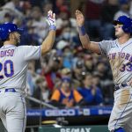 
              New York Mets' James McCann (33) is congratulated by Pete Alonso (20) after he scored on an RBI by Francisco Lindor (12) during the seventh inning of a baseball game against the Philadelphia Phillies, Monday, April 11, 2022, in Philadelphia. (AP Photo/Laurence Kesterson)
            
