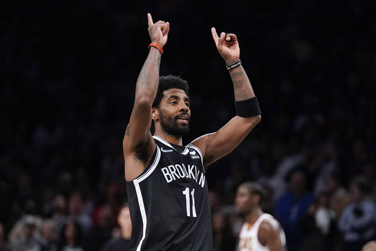 Brooklyn Nets' Kyrie Irving reacts after sinking a basket during the second half of the opening bas...
