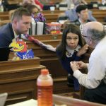 
              Kansas state Reps. Brandon Woodard, left, D-Lenexa; Stephanie Clayton, center, D-Overland Park, and House Minority Leader Tom Sawyer, right, D-Wichita, confer during a debate on a bill barring transgender athletes from competing in female school sports, Friday, April 1, 2022, at the Statehouse in Topeka, Kan. All three oppose the measure, but it has enough support in the Republican-controlled Legislature to pass. (AP Photo/John Hanna)
            