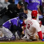 
              Philadelphia Phillies' Jean Segura, right, collides with Colorado Rockies catcher Dom Nunez to score on a double by Rhys Hoskins during the fourth inning of a baseball game, Tuesday, April 26, 2022, in Philadelphia. (AP Photo/Matt Slocum)
            