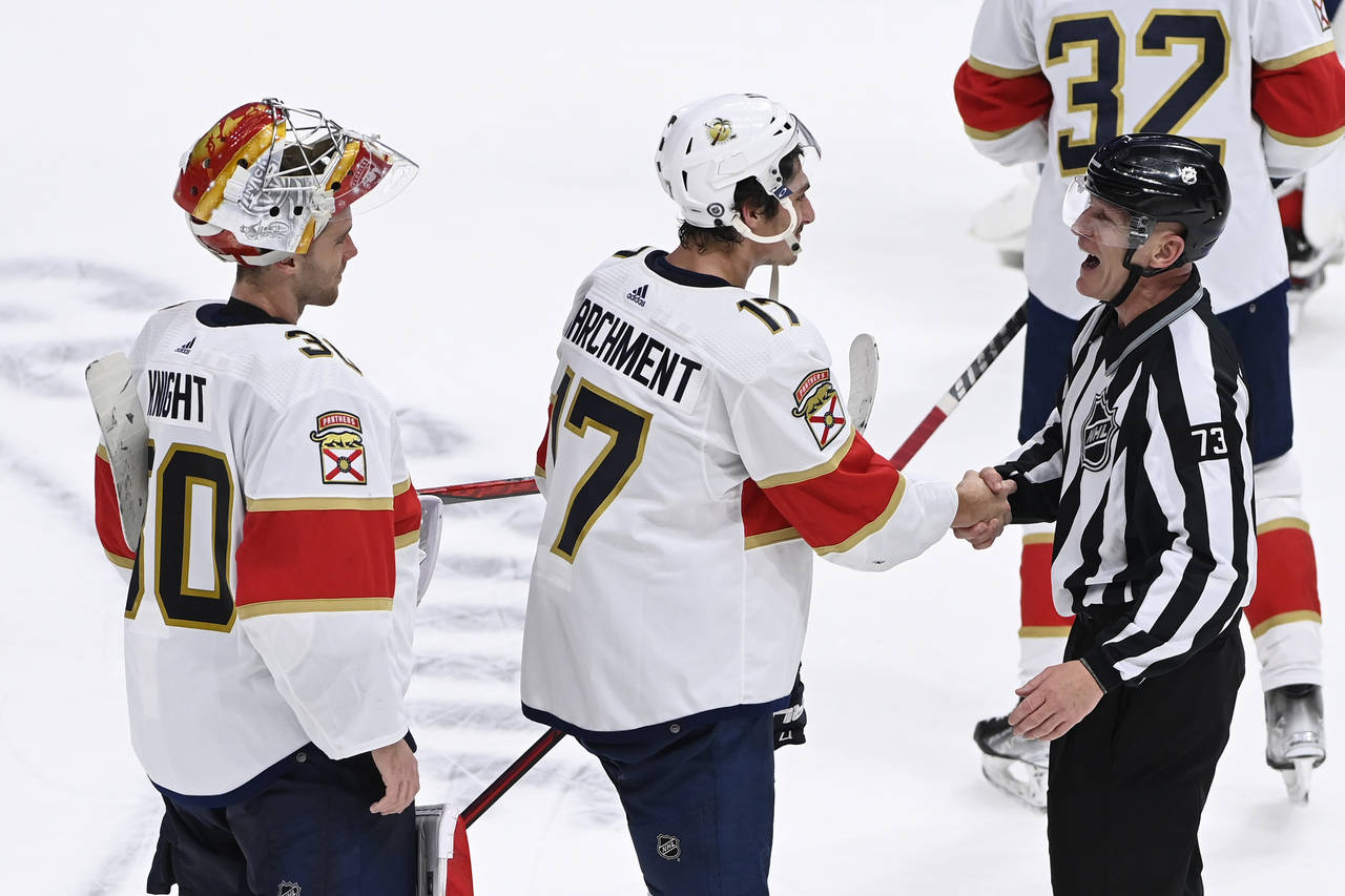 Linesman Vaughan Rody (73) shakes hands with Florida Panthers left wing Mason Marchment (17) as goa...