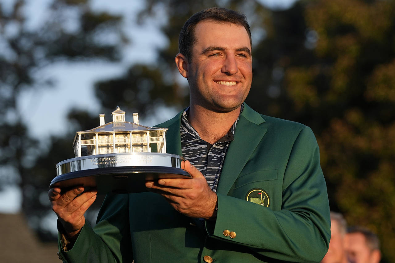 Scottie Scheffler holds the championship trophy after winning the 86th Masters golf tournament on S...