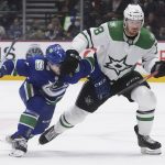 
              Vancouver Canucks' Nic Petan, left, and Dallas Stars' Michael Raffl, of Austria, vie for the puck during the second period of an NHL hockey game in Vancouver, B.C., Monday, April 18, 2022. (Darryl Dyck/The Canadian Press via AP)
            