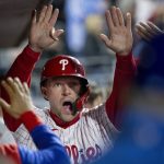 
              Philadelphia Phillies' Rhys Hoskins is cheered in the dugout after scoring on an RBI double by Didi Gregorius during the eighth inning of a baseball game against the New York Mets, Monday, April 11, 2022, in Philadelphia. (AP Photo/Laurence Kesterson)
            