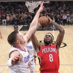 
              New Orleans Pelicans forward Naji Marshall, right, shoots as Los Angeles Clippers center Isaiah Hartenstein defends during the second half of an NBA basketball game Sunday, April 3, 2022, in Los Angeles. (AP Photo/Mark J. Terrill)
            