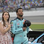 
              FILE - Driver Bubba Wallace, right, stands next to his vehicle with his fiancé Amanda Carter on pit road before a NASCAR Cup Series auto race at Daytona International Speedway, Saturday, Aug. 28, 2021, in Daytona Beach, Fla.  Wallace’s rain-shortened win at Talladega Superspeedway last October was a career breakthrough, but now Wallace wants more. He returns to Talladega for Sunday’s race as a legitimate threat, and Wallace does believe he can win. (AP Photo/Phelan M. Ebenhack, File)
            