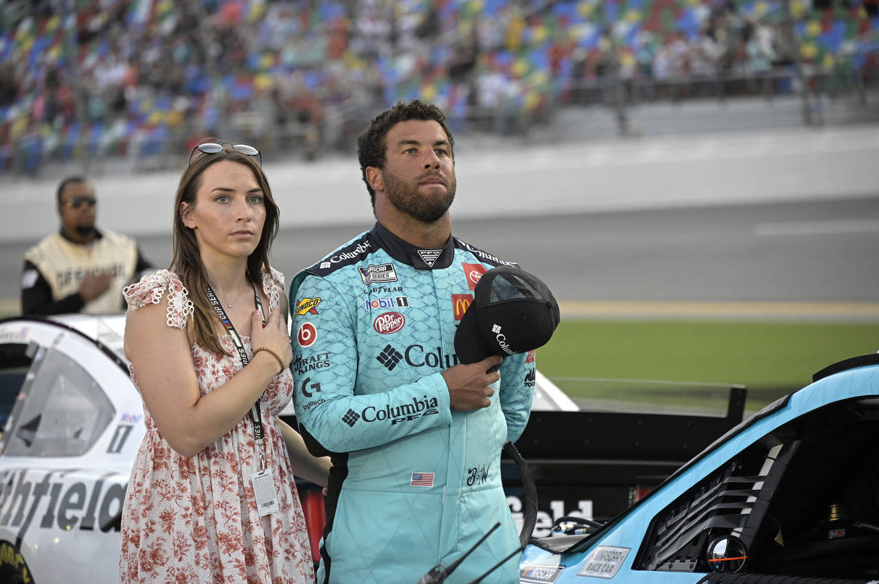FILE - Driver Bubba Wallace, right, stands next to his vehicle with his fiancé Amanda Carter on pi...