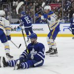 
              Toronto Maple Leafs forward Colin Blackwell (11) sits on the ice as Buffalo Sabres' Rasmus Dahlin (26) and Casey Mittelstadt (37) celebrate a goal during the third period of an NHL hockey game Tuesday, April 12, 2022, in Toronto. (Nathan Denette/The Canadian Press via AP)
            