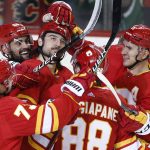
              Calgary Flames defenseman Christopher Tanev, center, celebrates with teammates after scoring against the Dallas Stars during the third period of an NHL hockey game Thursday, April 21, 2022, in Calgary, Alberta. (Larry MacDougal/The Canadian Press via AP)
            
