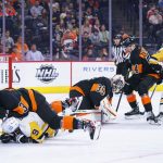 
              Philadelphia Flyers' Martin Jones, center, covers up the puck as his defense keeps Pittsburgh Penguins players away during the first period of an NHL hockey game, Sunday, April 24, 2022, in Philadelphia. (AP Photo/Chris Szagola)
            