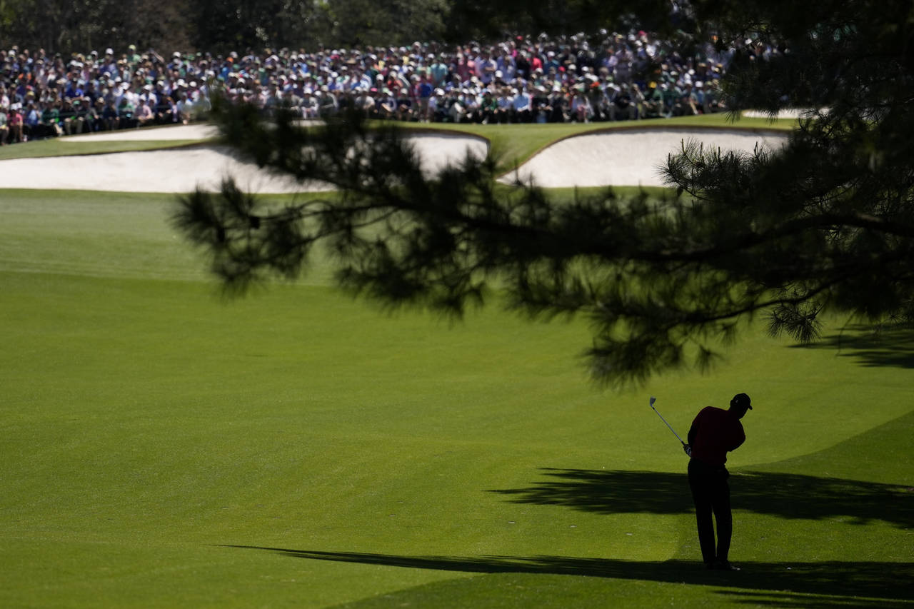 Tiger Woods hits on the seventh fairway during the final round at the Masters golf tournament on Su...