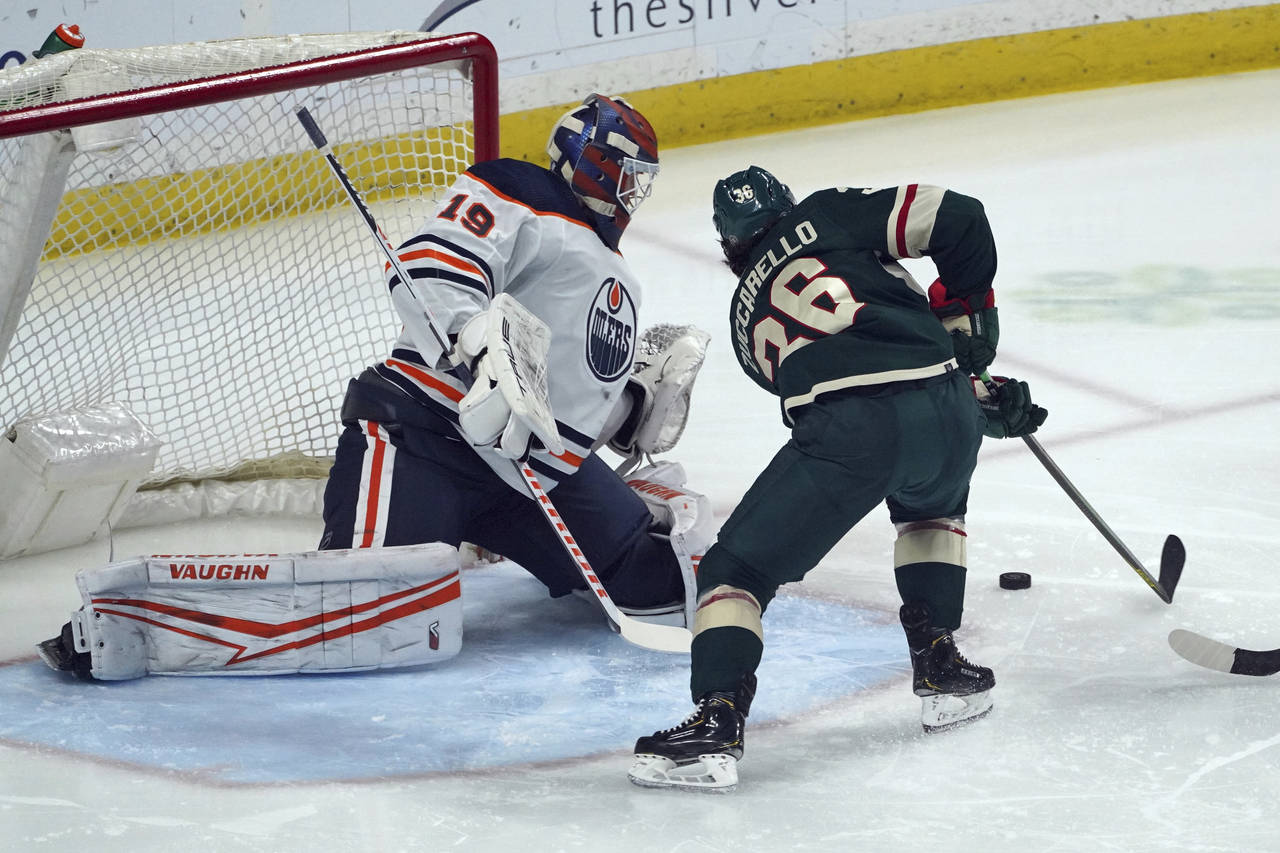 Edmonton Oilers goalie Mikko Koskinen (19) defends as Minnesota Wild's Mats Zuccarello attempts a s...