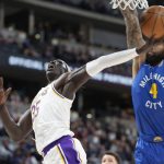 
              Los Angeles Lakers forward Wenyen Gabriel, left, drives to the rim for a basket as Denver Nuggets center DeMarcus Cousins defends in the first half of an basketball game Sunday, April 10, 2022, in Denver. (AP Photo/David Zalubowski)
            