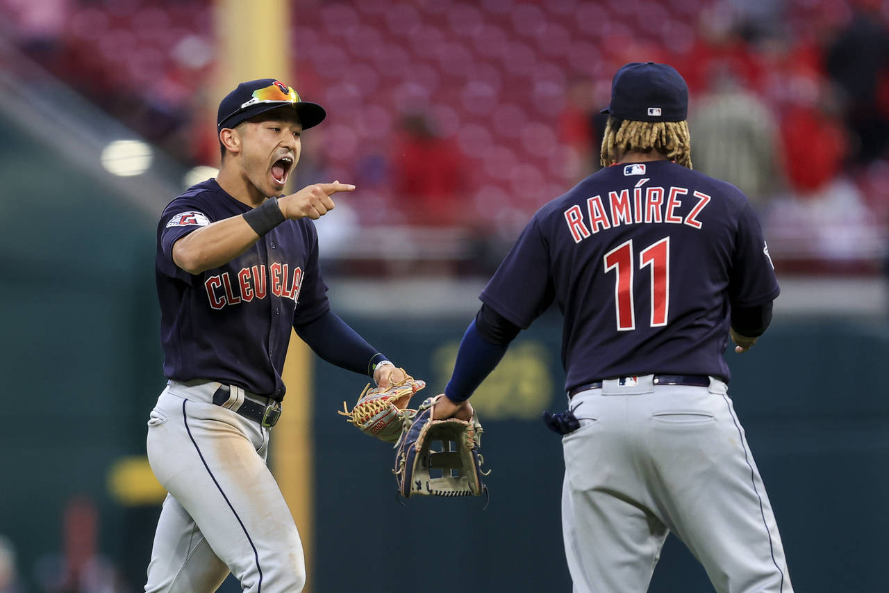 Cleveland Guardians' Andres Gimenez, left, points as he yells to celebrate with Jose Ramirez after ...