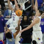 
              Kansas' Christian Braun (2) Mitch Lightfoot (44) defend against a shot by North Carolina guard R.J. Davis (4) during the first half of a college basketball game in the finals of the Men's Final Four NCAA tournament, Monday, April 4, 2022, in New Orleans. (AP Photo/Gerald Herbert)
            