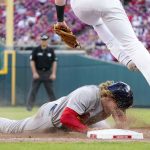 
              St. Louis Cardinals' Harrison Bader, bottom, steals third base during the eighth inning of a baseball game against the Cincinnati Reds, Saturday, April 23, 2022, in Cincinnati. (AP Photo/Jeff Dean)
            