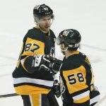 
              Pittsburgh Penguins' Kris Letang (58) is congratulated by Sidney Crosby (87) after scoring against the New York Islanders during the first period of an NHL hockey game, Thursday, April 14, 2022, in Pittsburgh. (AP Photo/Keith Srakocic)
            