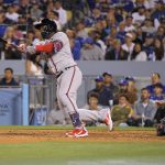 
              Atlanta Braves' Guillermo Heredia, left, hits a solo home run as Los Angeles Dodgers catcher Will Smith watches during the fifth inning of a baseball game Monday, April 18, 2022, in Los Angeles. (AP Photo/Mark J. Terrill)
            