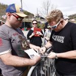 
              Gary LeVox, with the band Rascal Flatts, right, signs an autograph for Chris Hamlin before a NASCAR Cup Series auto race, Sunday, April 17, 2022, in Bristol, Tenn. (AP Photo/Wade Payne)
            