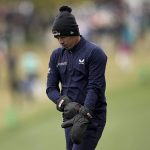 
              Matthew Fitzpatrick, of England, puts his mittens on after playing his second shot on the first fairway during the third round at the Masters golf tournament on Saturday, April 9, 2022, in Augusta, Ga. (AP Photo/David J. Phillip)
            