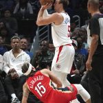 
              Los Angeles Clippers guard Luke Kennard, top, shoots as New Orleans Pelicans guard Jose Alvarado falls during the first half of an NBA basketball game Sunday, April 3, 2022, in Los Angeles. (AP Photo/Mark J. Terrill)
            