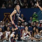 
              UConn's Paige Bueckers favors her leg as she walks off the court during the second half of a college basketball game in the semifinal round of the Women's Final Four NCAA tournament Friday, April 1, 2022, in Minneapolis. (AP Photo/Eric Gay)
            