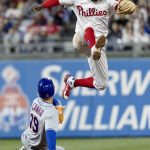 
              New York Mets' Mark Canha (19) is out at second as Philadelphia Phillies shortstop Didi Gregorius (18) leaps over him during the seventh inning of a baseball game, Tuesday, April 12, 2022, in Philadelphia. (AP Photo/Laurence Kesterson)
            