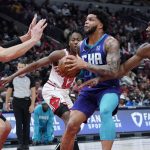 
              Charlotte Hornets forward Miles Bridges, center, drives to the basket against Chicago Bulls center Nikola Vucevic, left, forward Patrick Williams, right, and guard Ayo Dosunmu during the first half of an NBA basketball game in Chicago, Friday, April 8, 2022. (AP Photo/Nam Y. Huh)
            