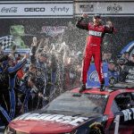 
              Ross Chastain, top, celebrates his win in Victory Lane after a NASCAR Cup Series auto race Sunday, April 24, 2022, in Talladega, Ala. (AP Photo/Butch Dill)
            