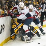 
              Pittsburgh Penguins' Sidney Crosby (87) is pinned against the boards by Washington Capitals' Martin Fehervary (42) and Nick Jensen (3) during the second period of an NHL hockey game, Saturday, April 9, 2022, in Pittsburgh. (AP Photo/Keith Srakocic)
            
