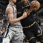
              Golden State Warriors' Kevon Looney (5) drives against San Antonio Spurs' Zach Collins during the first half of an NBA basketball game on Saturday, April 9, 2022, in San Antonio. (AP Photo/Darren Abate)
            