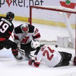 
              Ottawa Senators right wing Drake Batherson (19) scores on New Jersey Devils goaltender Mackenzie Blackwood (29) as Devils defenseman Ty Smith (24) sprawls on the ice during the overtime period of an NHL hockey game in Ottawa, on Tuesday, April 26, 2022. (Justin Tang/The Canadian Press via AP)
            